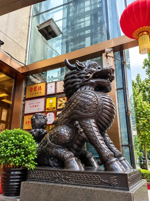 China, Guardian Lion at a Glass Atrium Entrance
