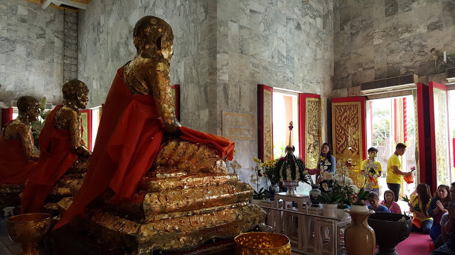 gold leaf monk statues in temple in Phuket Thailand