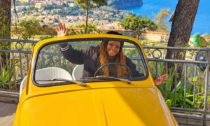 Italy, Stacey, Wave in a Vintage Yellow Car