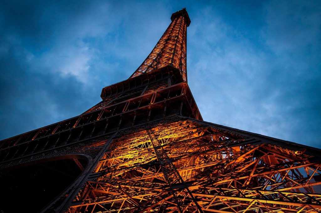 Paris Eiffel Tower at night lights up the sky over Paris
