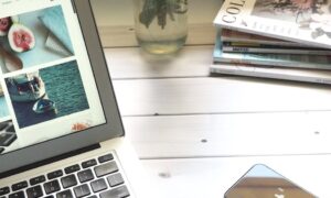 macbook air flower bouquet and magazines on white table