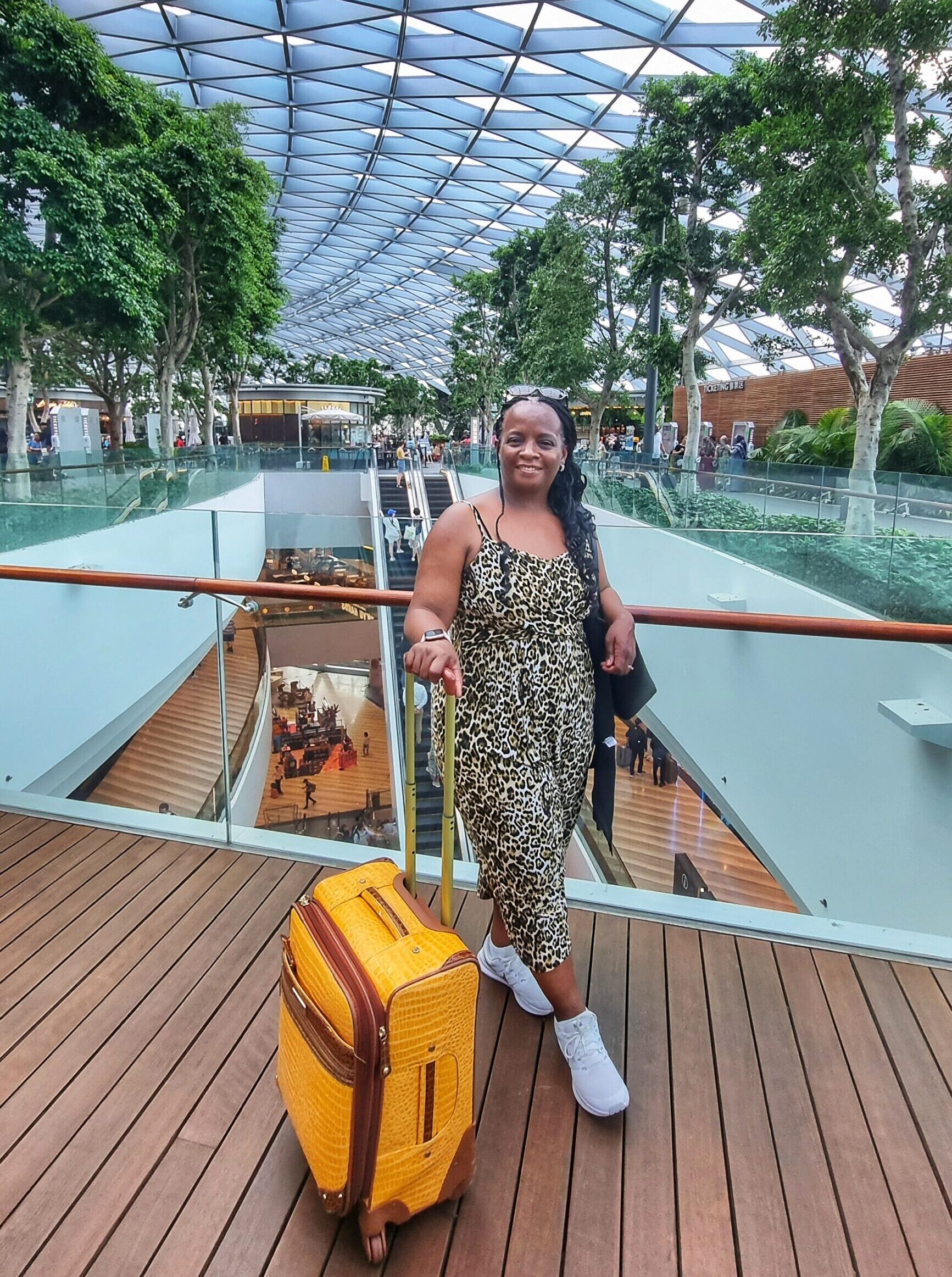 Stacey at Changi Airport with yellow carryon luggage