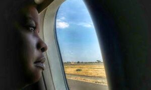 military spouse staring out airplane window- featured image