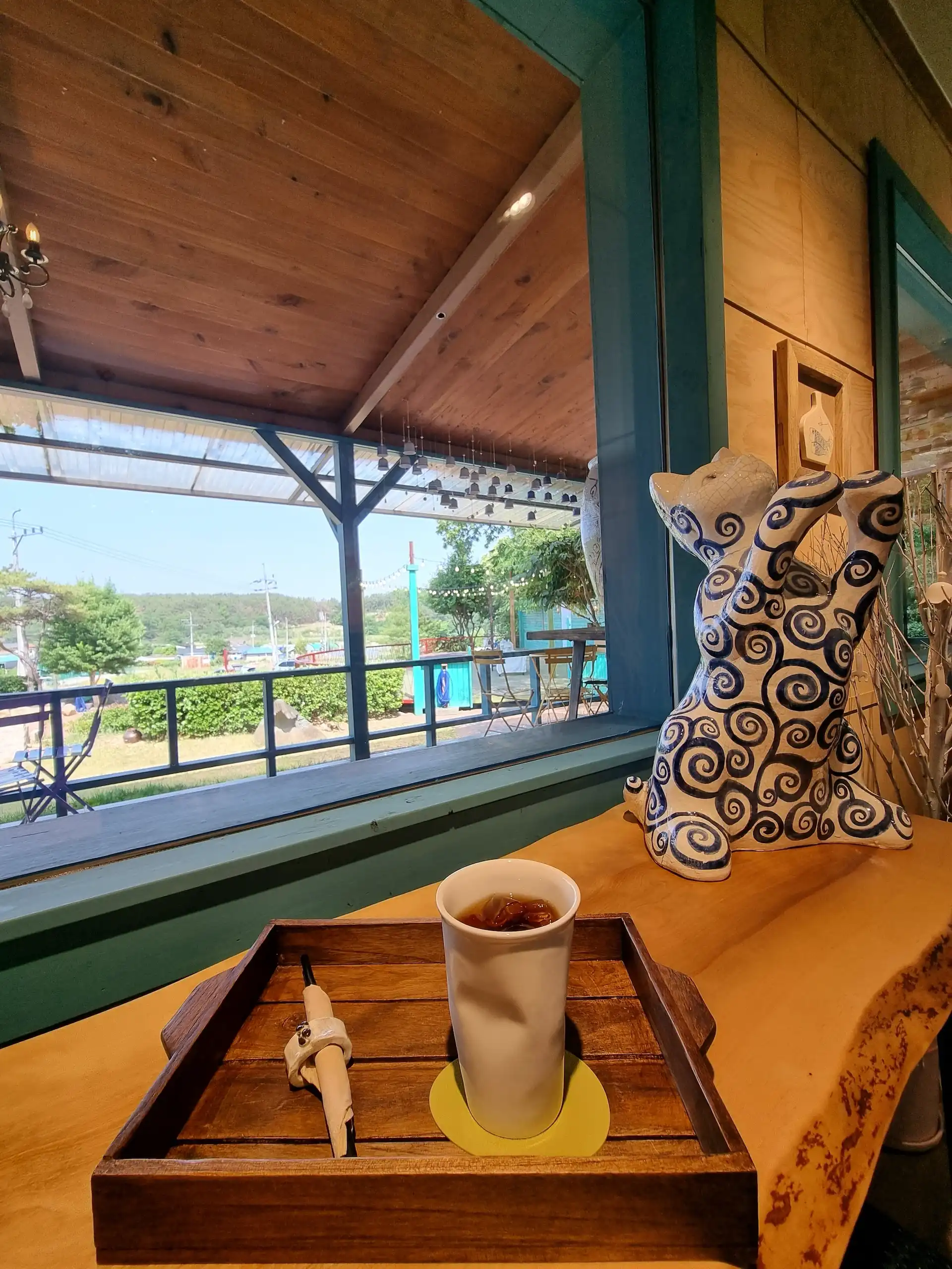 Coffee in Pottery, picture window, cat, crumpled ceramic cup