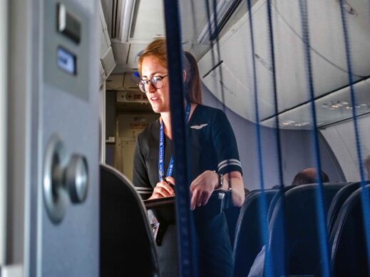 January 18 2018 United airlines flight USA; a flight attendant is seen helping  travelers in first class on an airplane  in mid flight