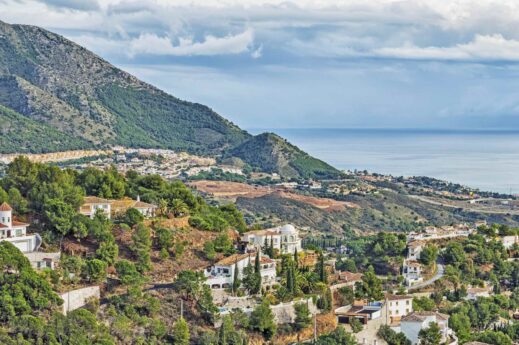 This great view of Mijas Spain overlooking the Mediterranean Sea with the variety of home on the hillside under a magnificant clouds sky is a great Postcard view.