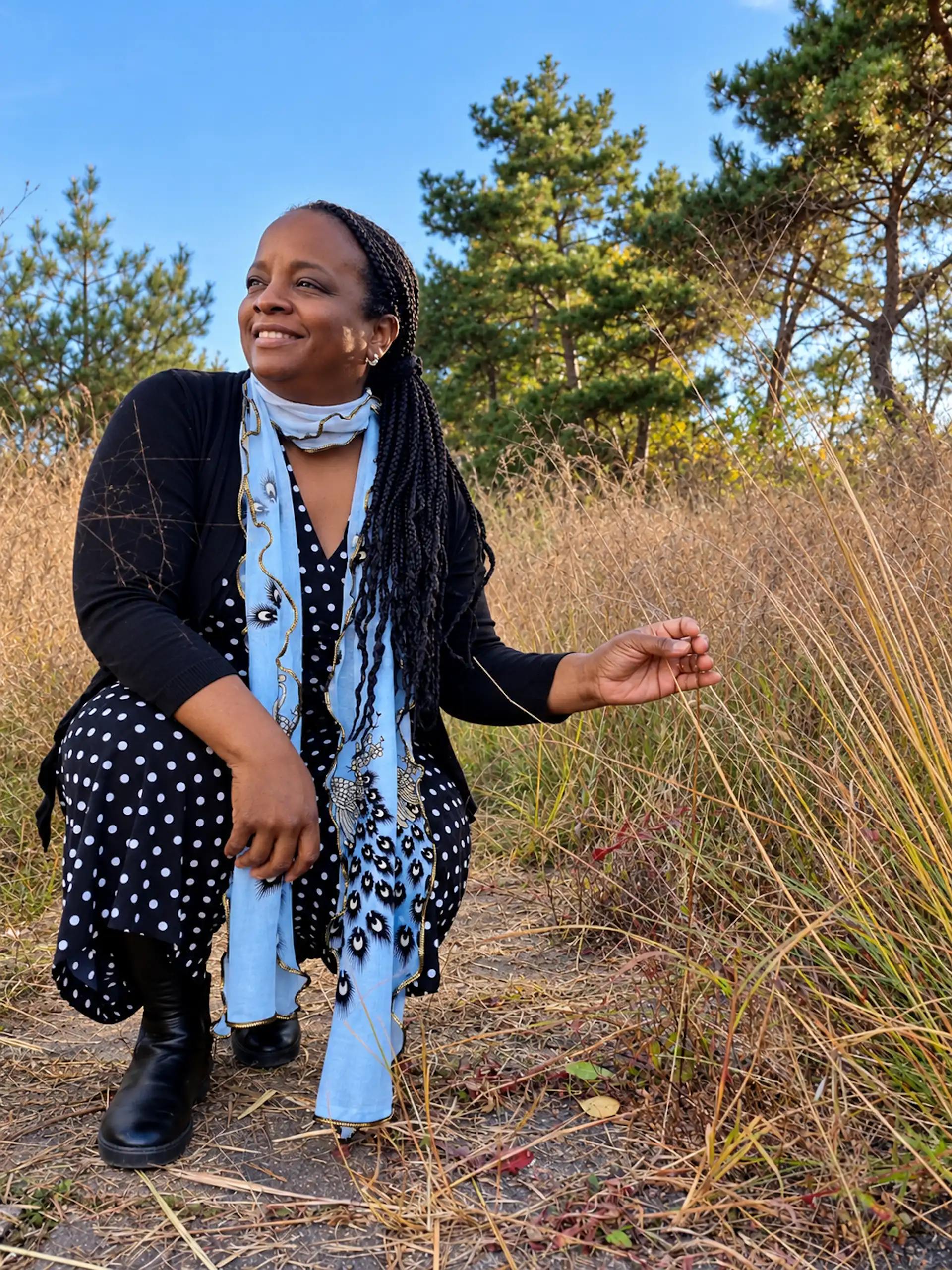 Stacey kneeling tall grass