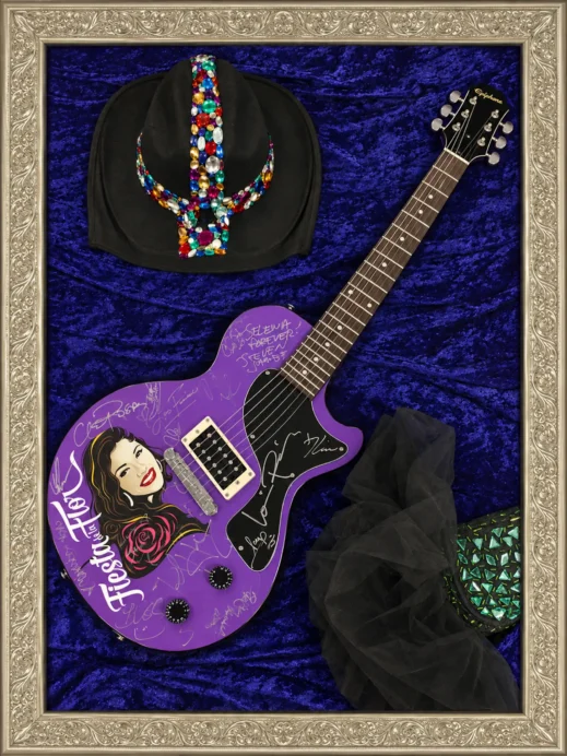 Ornate silver frame around guitar exhibit