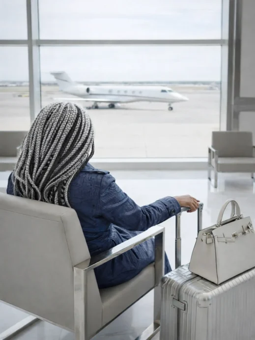 black woman, silver braids, airport, plane on runway